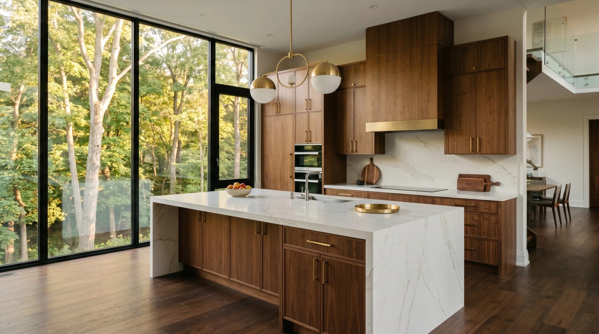 A grand Kleinburg-style Vaughan luxury kitchen with an expansive white engineered porcelain waterfall island with a mitered edge on walnut cabinetry beside soaring windows onto a wooded landscape — Distinctive Form serves Vaughan