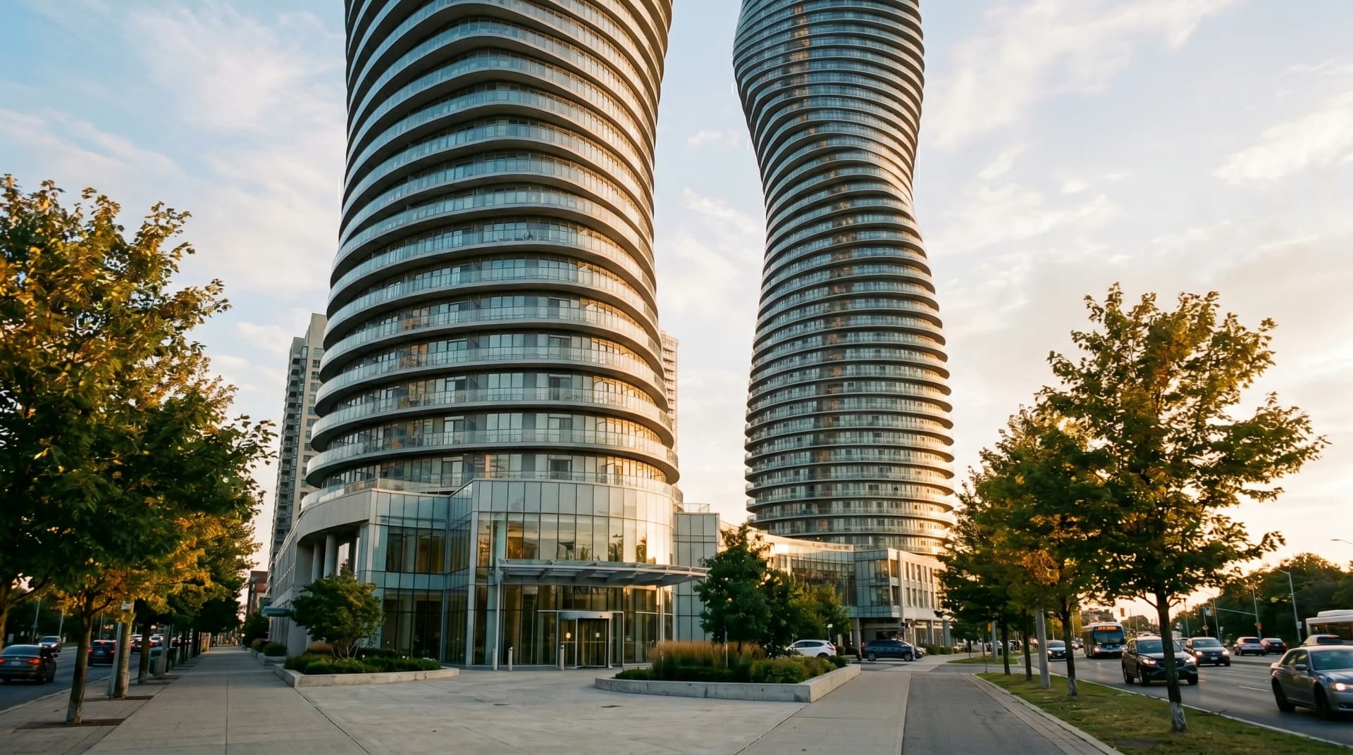 The iconic Absolute World "Marilyn Monroe" curving twisting glass condo towers in Mississauga City Centre at golden hour — the dense high-rise condo cluster Distinctive Form coordinates installations across in Mississauga