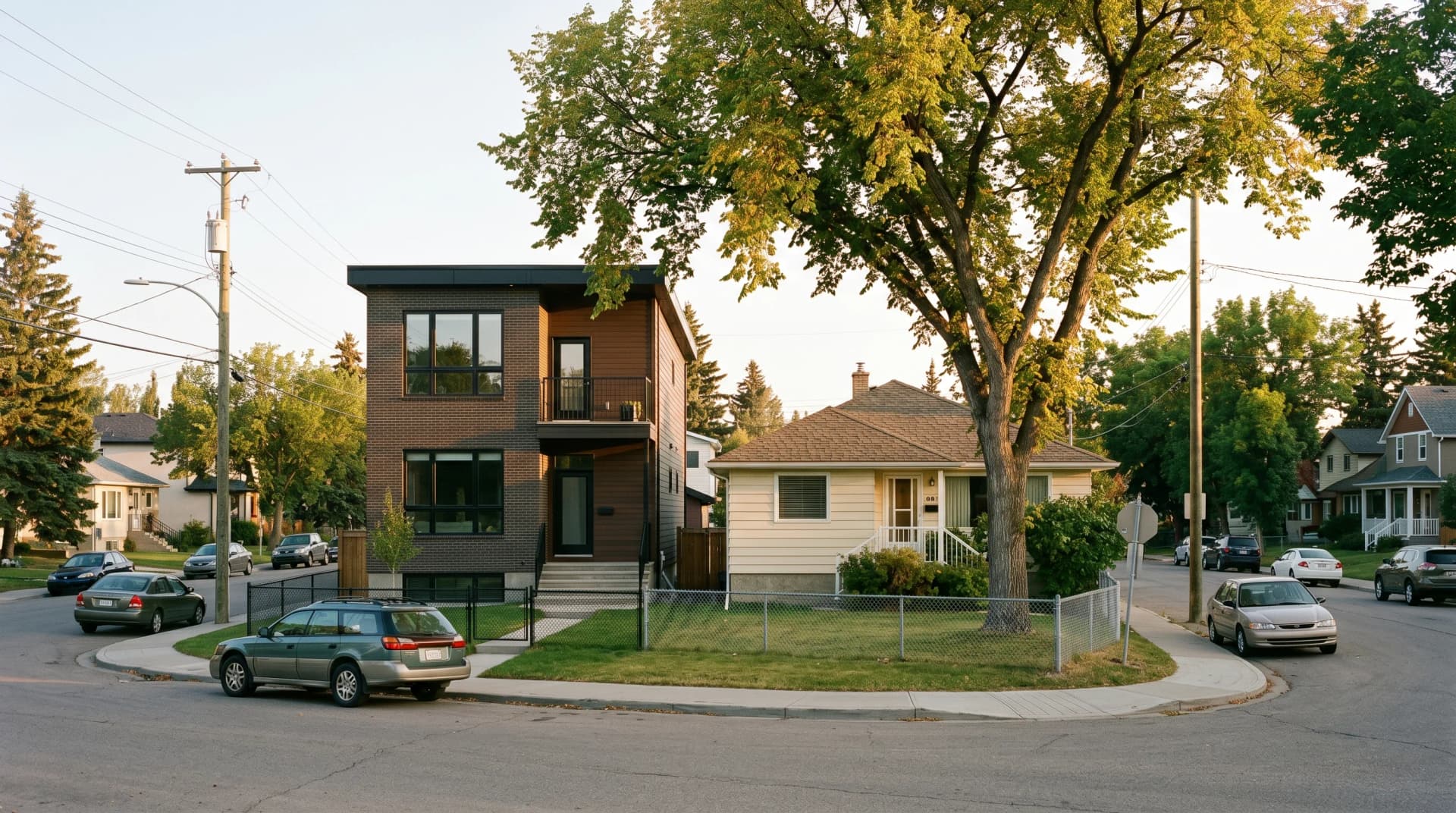 A modern three-story Calgary infill home standing next to an older postwar bungalow on a Bridgeland-style inner-city street — typical of the infill renovations we work on