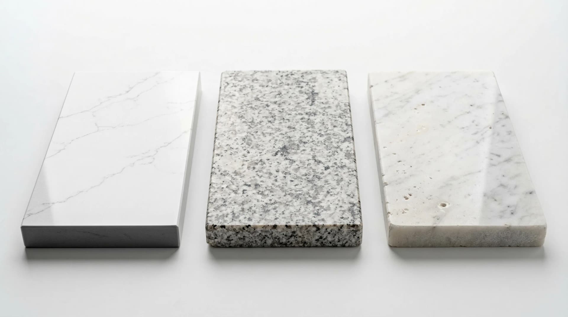Distinctive Form — engineered quartz vs natural granite vs natural marble comparison. Three polished countertop material samples arranged side by side: engineered quartz with consistent white Calacatta-style veining and perfectly uniform non-porous surface (left), natural granite with organic speckled crystals and visible mineral inclusions requiring periodic sealing (center), and natural marble with characteristic warm veining but visible pores and higher maintenance demands (right), illustrating porosity, consistency, and maintenance differences.
